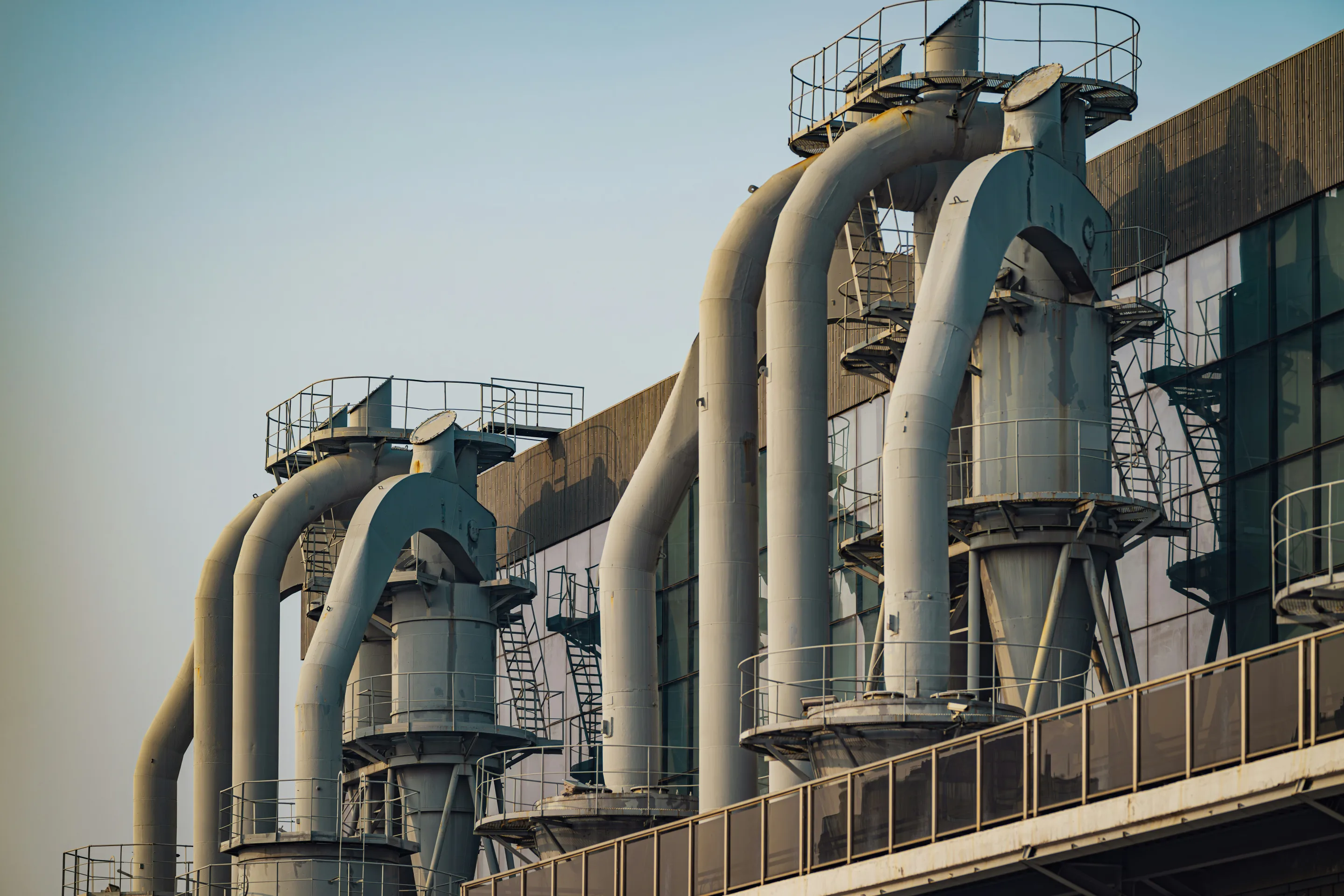 Industrial facility with large process ducts, platforms, and access ladders.
